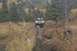 1990 Chevrolet Suburban - A 1990 Chevrolet Suburban navigates a challenging, muddy off-road trail surrounded by autumn foliage.