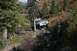 1990 Chevrolet Suburban - SUV tackling a challenging muddy and rocky off-road trail surrounded by trees.