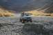 1990 Chevrolet Suburban - A Chevrolet Suburban navigates a , rocky terrain in a mountainous valley.