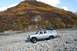 1990 Chevrolet Suburban - A 1990 Chevrolet Suburban navigates a rocky riverbed under a colorful mountain landscape.