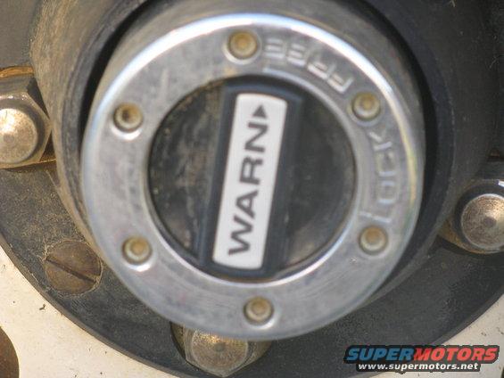 Close-up of a Warn manual locking hub with 'WARN' and 'FREE LOCK' text visible