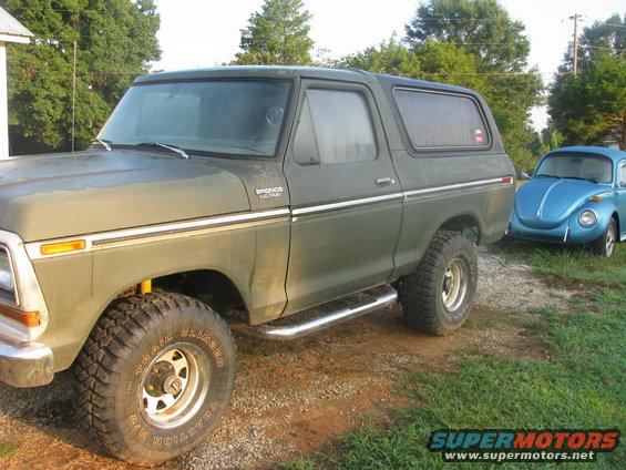 Green 1978 Ford Bronco parked next to a blue Volkswagen Beetle
