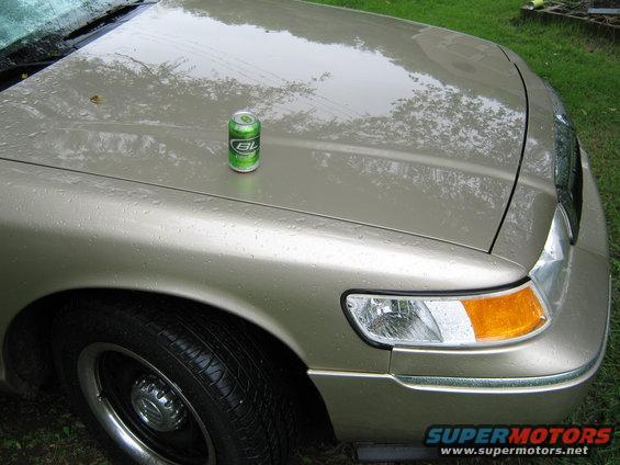 Gold 2000 Mercury Grand Marquis hood with a green soda can on it