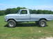 1975 Ford F-250 - Side profile of a lifted 1975 Ford F-250 pickup truck with off-road tires, painted in primer.