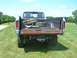 1975 Ford F-250 - This lifted Ford pickup truck has a rusty tailgate and two spare tires loaded in the bed.