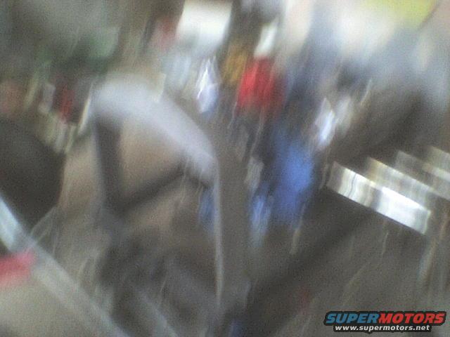 Blurry image of a truck's side with some people in the background