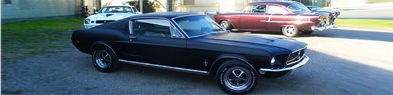Black 1968 Ford Mustang coupe, 3q-front view. Other cars in background