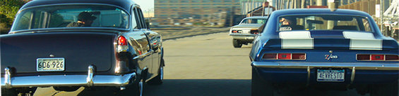Blue 1969 Camaro Z/28 with white stripes, dark purple 1955 Chevrolet, and a white car in the distance