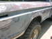 1975 Ford F-250 - Side view of a truck body undergoing repair, revealing primer and body filler.