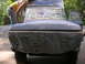 1975 Ford F-250 - A person sands the hood of a 1975 Ford F-250 truck, which is covered in newspaper for protection during preparation for painting.