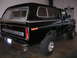 1975 Ford F-250 - This black 1975 Ford F-250 pickup truck is equipped with a camper shell and chrome accents.
