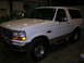 1975 Ford F-250 - This white Ford Bronco is shown from a three-quarter front view, parked indoors.