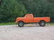 1975 Ford F-250 - This orange pickup truck, likely from the early to mid-1970s, is shown from the side on a gravel lot.