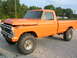 1975 Ford F-250 - This orange Ford F-250 pickup truck is shown from the side with its hood slightly ajar.