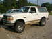 1975 Ford F-250 - This 1992 Ford Bronco is parked next to another vehicle on a gravel lot.