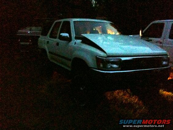 Light-colored SUV, hood is bent up. Another vehicle is partially visible behind it