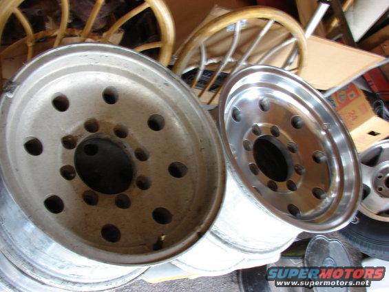 Two aluminum truck wheels stacked, one in foreground, another to the right