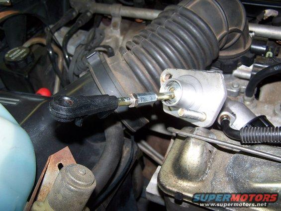 Close-up of a clutch master cylinder and linkage in an engine bay
