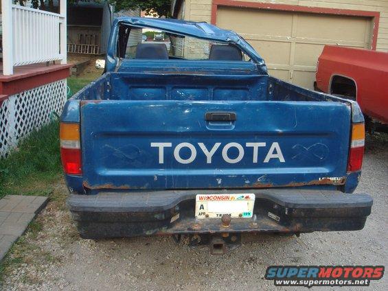 Blue Toyota pickup truck rear view, damaged roof, Wisconsin license plate