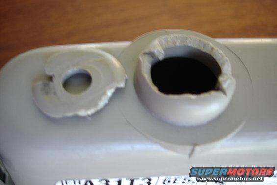 Gray plastic part with two broken mounting holes, one with torn edges