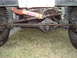 1995 Ford Bronco - The rear axle and suspension components of a vehicle are visible, including a shock absorber and steering linkage.