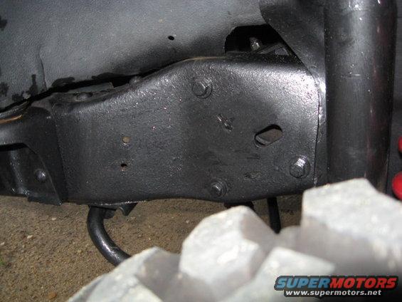 Close-up of a vehicle's black painted frame and a large tire tread