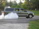 2001 Ford Excursion - A green Ford Excursion performs a burnout, kicking up a large cloud of smoke from its rear tires.