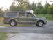 2001 Ford Excursion - Side profile of a Ford Excursion SUV, likely from the early 2000s, on a paved road.