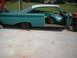 1960 Ford Starliner - A turquoise and white 1960 Ford Starliner body sits on a concrete surface, stripped of its doors and hood.