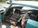 1960 Ford Starliner - Interior of a heavily rusted car, parts scattered around. A white car is visible in the background.