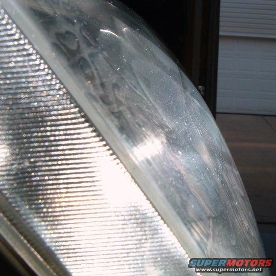 Close-up of a scratched headlight lens with horizontal fluting