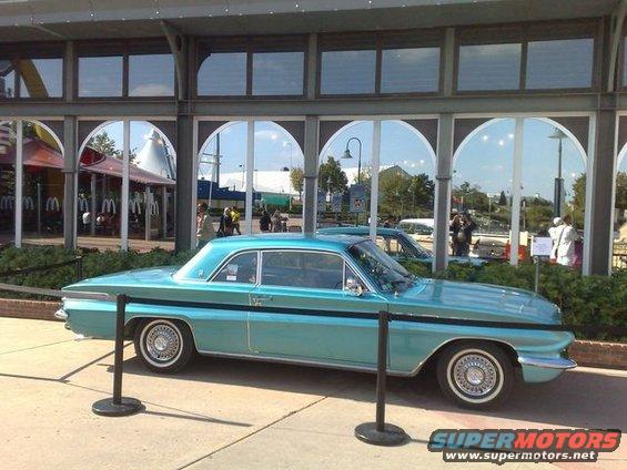 Teal 1961 Oldsmobile Dynamic 88 coupe parked outside a building with arched windows