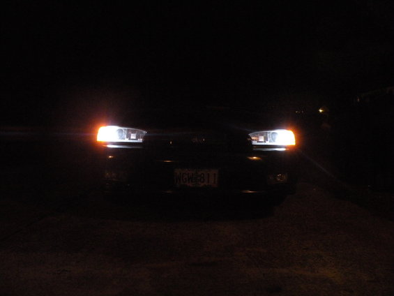 1998 Subaru Legacy front view at night, headlights on, license plate NGH 811 visible
