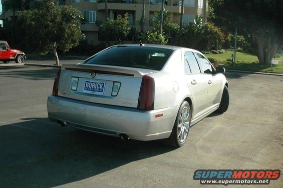 Rear view of a silver 2006 Cadillac STS parked on pavement. A red Jeep is visible to the left