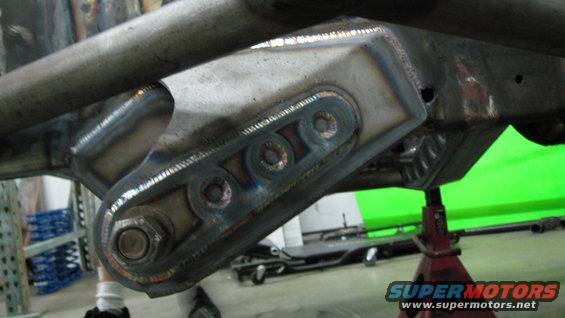 Close-up of a custom-welded suspension bracket with multiple bolt holes