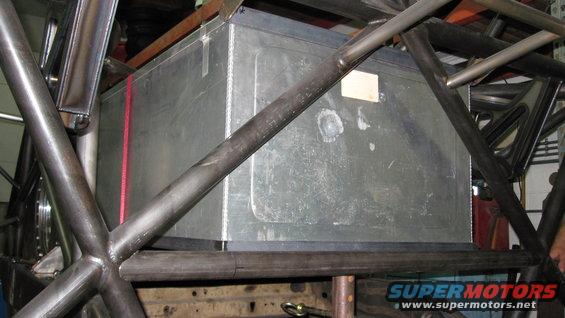 Custom fuel tank with red strap inside roll cage