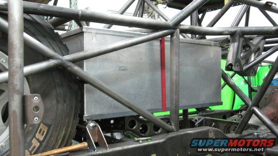 Custom roll cage structure with a metal fuel cell and a tire visible