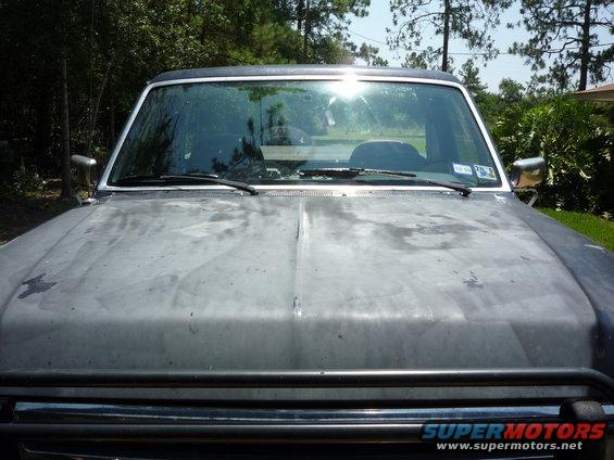 1990 Ford Bronco front view, showing hood and windshield. A inspection sticker is visible on the windshield