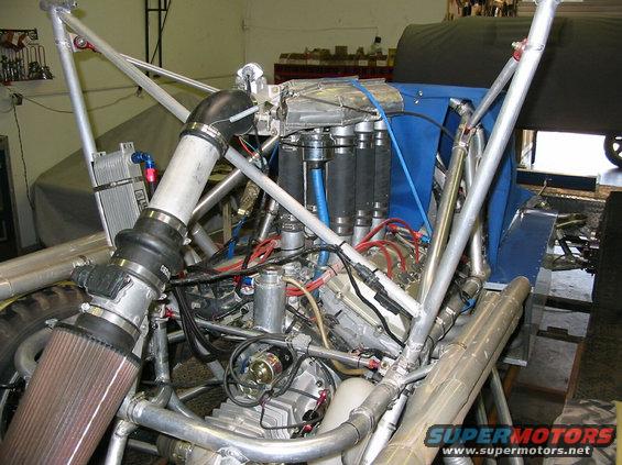 Engine with custom intake and exhaust, blue fabric cover, silver roll cage