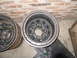 1984 Ford Bronco II - A close-up view of two vehicle wheels, one in front of the other, against a brick wall.