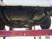 1977 Ford Mustang II - The underside of a vehicle is shown, with the fuel tank and exhaust system visible.