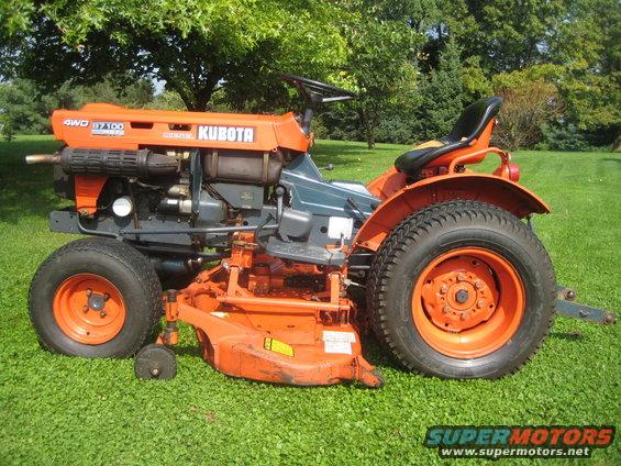 Orange Kubota tractor with mower deck, 4WD B7100 model designation