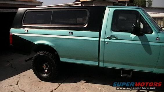 1994 Ford F-150 pickup truck, teal body with black camper shell, side view