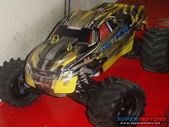 Yellow and black remote control monster truck with large tires. Traxxas logo visible