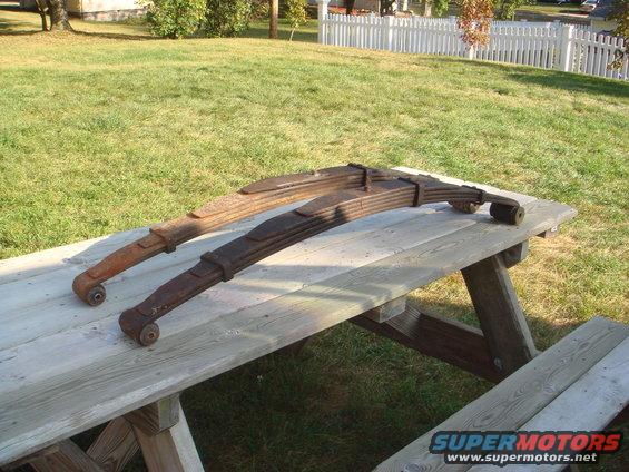 two rusty leaf springs on a wooden picnic table