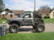 1984 Ford Bronco II - This heavily modified pickup truck, likely from the 1980s, features oversized tires and a custom roll cage.