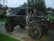 1984 Ford Bronco II - This heavily modified truck features a custom roll cage and oversized tires, with a second vehicle visible in the driveway.