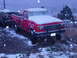1989 Ford F-250 - Red 1989 Ford F-250 pickup truck sits in the snow with another vehicle visible in the background.
