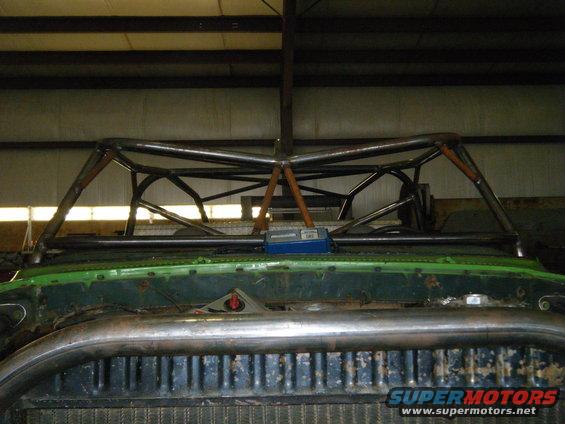Custom roll cage installed over the front of a green vehicle, obscuring the interior