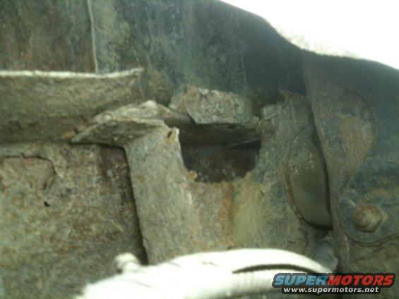 close-up of heavily rusted metal frame and suspension components of a vehicle